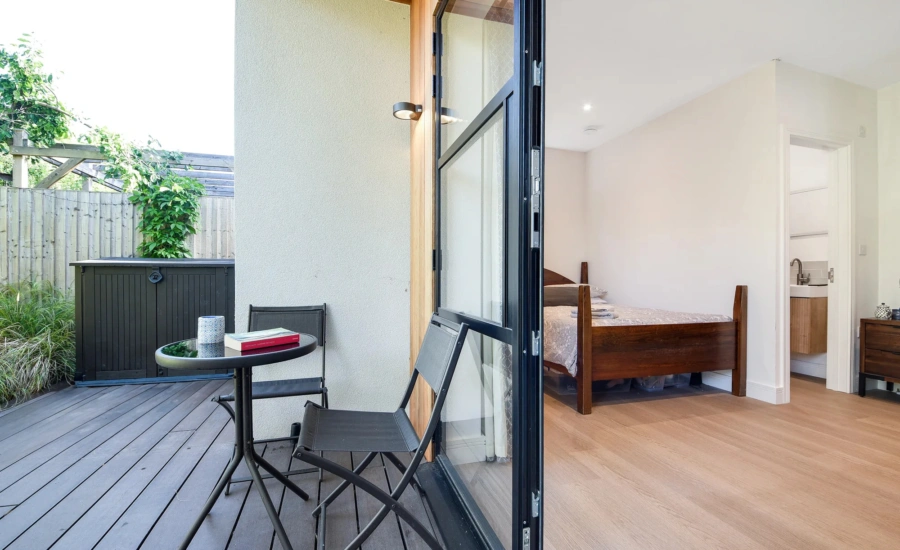 Compact garden annexe interior with bespoke fitted furniture storage and sleeping space